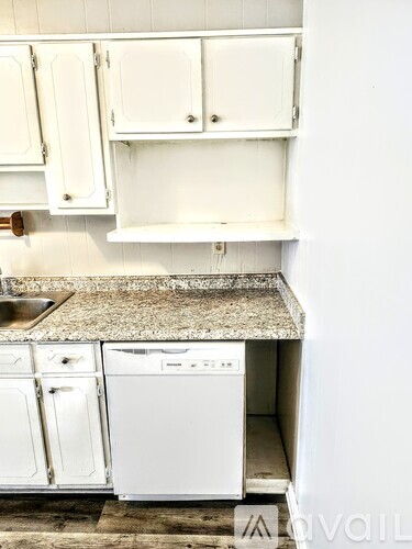 A white washing machine is in a kitchen.
