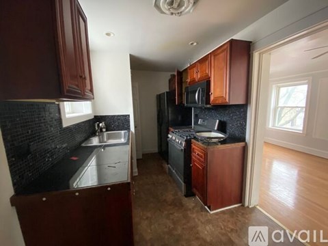 A kitchen with brown cabinets and black appliances.