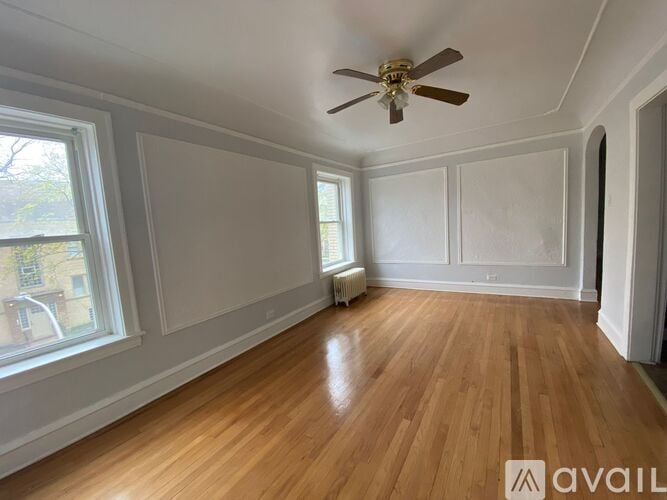 A room with wooden floors and a ceiling fan.
