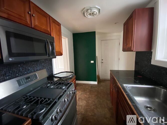 A kitchen with a black stove top oven and a black microwave above it.