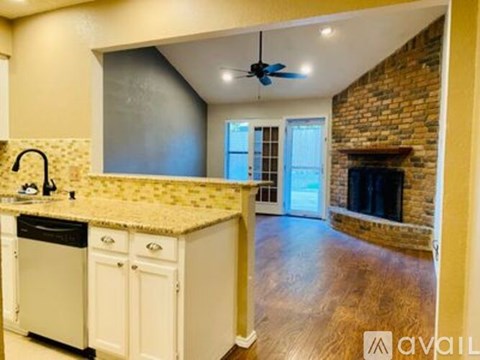 A kitchen with a brick fireplace and a ceiling fan.