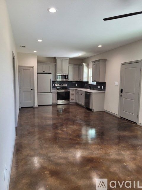 A kitchen with brown flooring and white walls.
