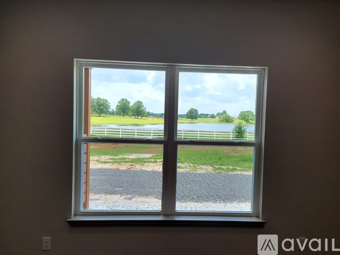 A room with a ceiling fan and brown floor.