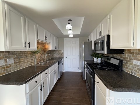 A kitchen with white cabinets and a black stove top oven.