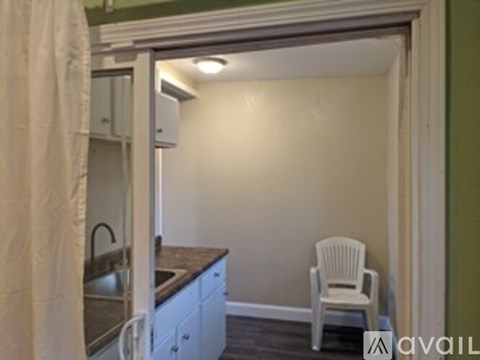 A kitchen with a sink and a chair in it.