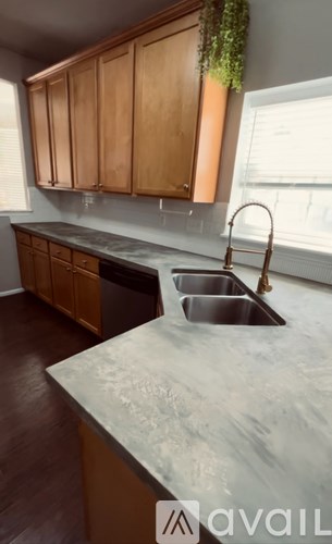 A kitchen with wooden cabinets and a marble countertop.