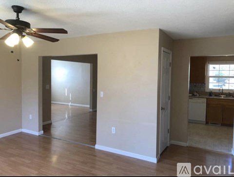 A room with a ceiling fan and a door leading to another room.