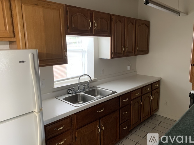 A kitchen with wooden cabinets and a white refrigerator.