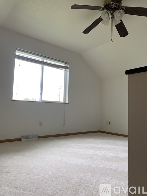 A room with a ceiling fan and a window.