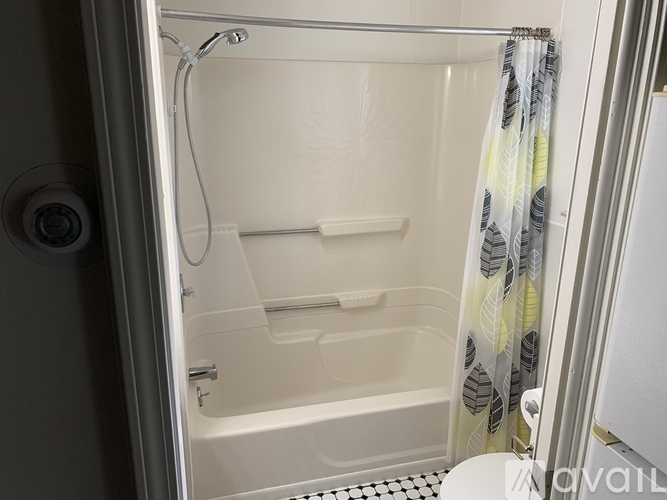 A shower area with a glass door and a shower head.