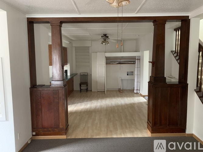 A living room with a wooden cabinet and a grey carpet.
