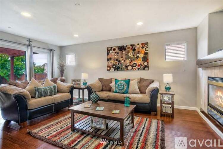 A living room with a large painting on the wall and a fireplace.