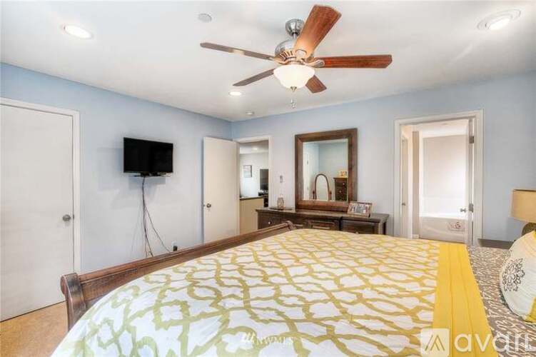 A bedroom with a large bed and a ceiling fan.