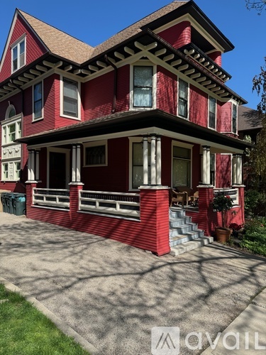 A red house with white trim and a porch.
