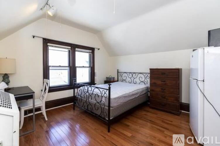 A bedroom with a bed, desk, and chair.