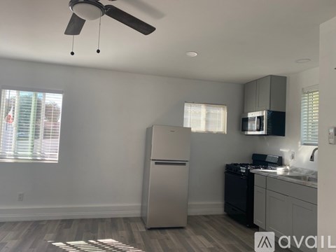 A kitchen with a stainless steel refrigerator and a fan on the ceiling.