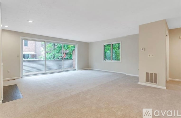 A spacious room with a large window and sliding glass doors.
