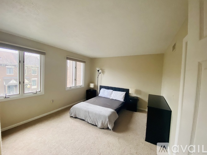 A bedroom with a bed, nightstand, and window.