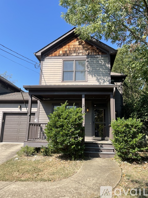 A house with a grey siding and a brown roof with a small porch and a grey door.