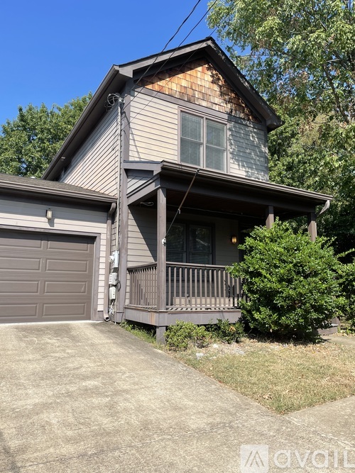 A house with a garage and a porch is for sale.