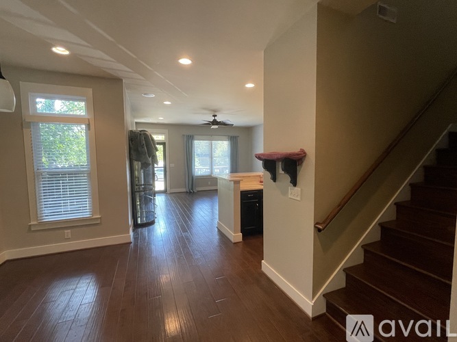 A spacious living room with hardwood floors and a staircase leading to the upper level.