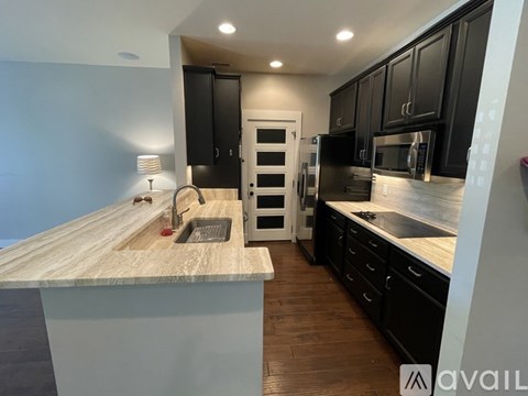 A kitchen with black cabinets and a wooden countertop.