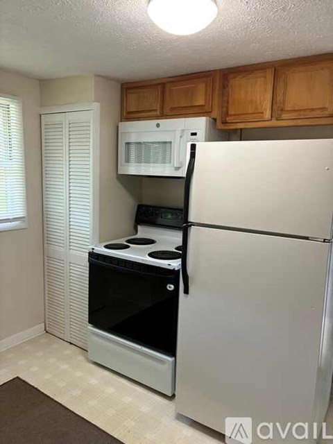 A white refrigerator with a black handle is in a kitchen.