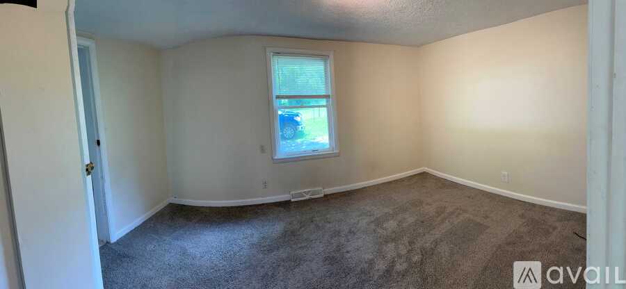A room with a window and carpeted floor.