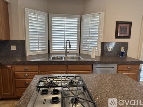 A kitchen with a granite countertop and a stove top.