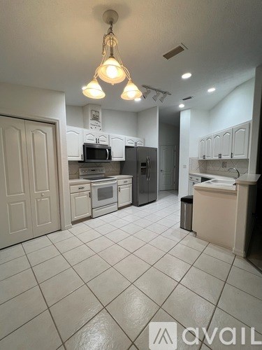 A kitchen with white cabinets and appliances.