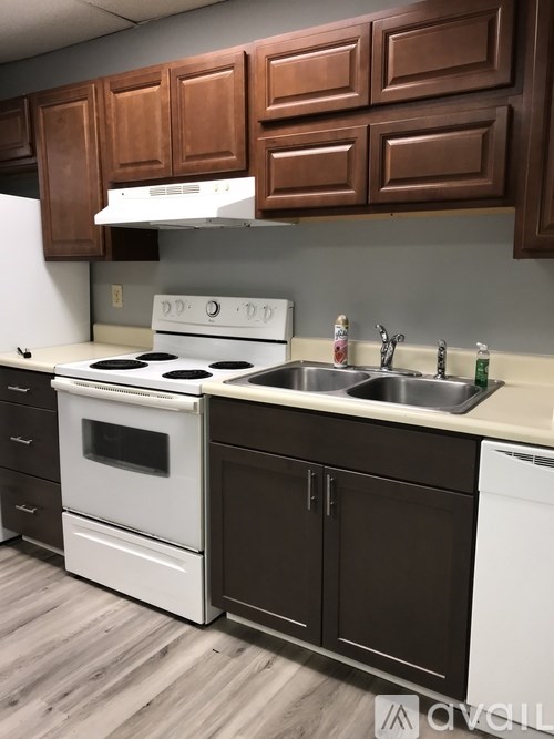 A white stove and oven in a kitchen with brown cabinets.