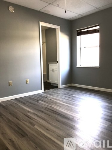 A room with a wooden floor and a white door.