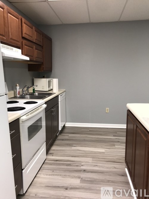 A kitchen with white appliances and wooden cabinets.