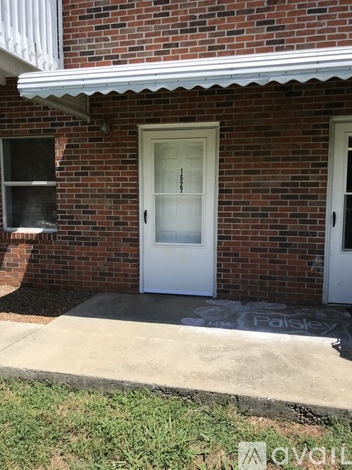 A white door is on the front of a brick house.