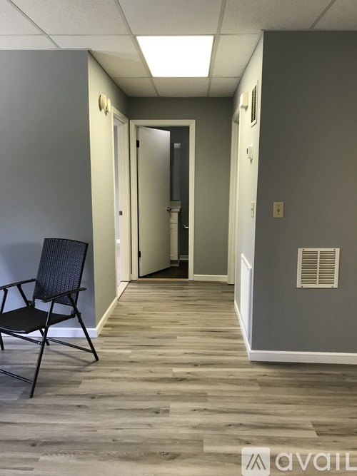 A hallway with a chair and a door.