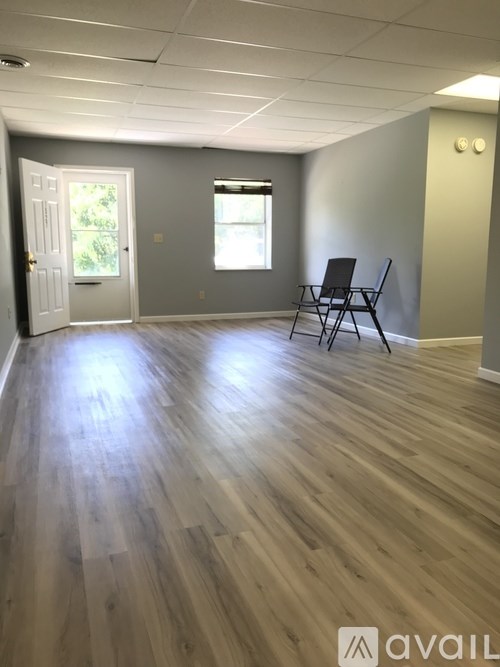 A room with wooden flooring and a single chair.