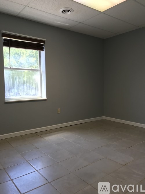 A room with a window and tiled floor.