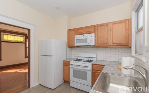 A kitchen with white appliances and wooden cabinets.