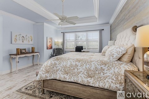 A bedroom with a large bed and a ceiling fan.