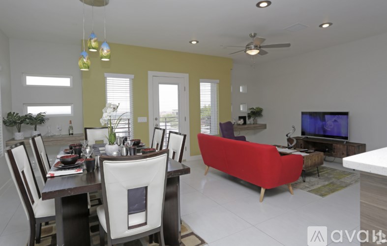 A modern dining room with a red sofa and a television.