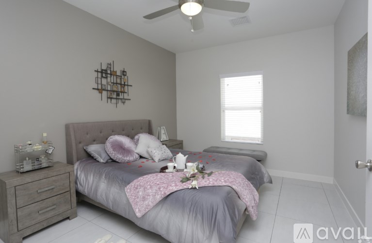 A bedroom with a bed, dresser, and ceiling fan.