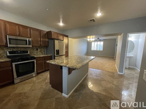 A kitchen with brown cabinets and a granite countertop.