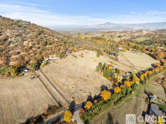 A bedroom with a bed, nightstand, and window with blinds.