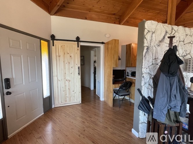 A room with wooden floors and a stone wall.