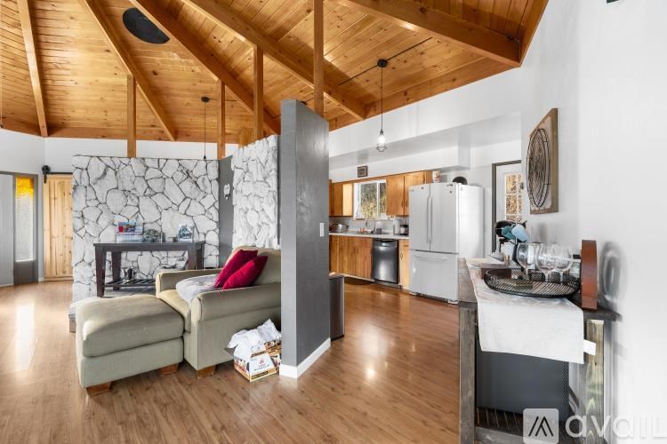 A modern kitchen with a wooden ceiling and a dining area with a white table and chairs.
