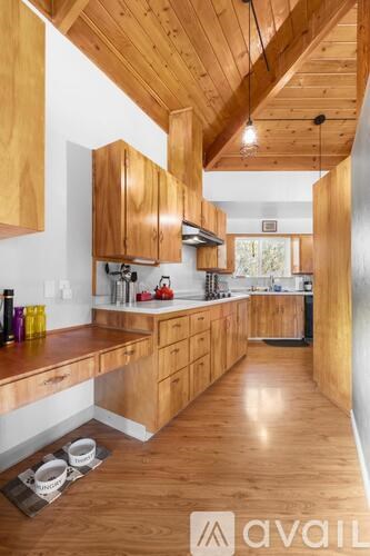 A kitchen with wooden cabinets and a wooden floor.