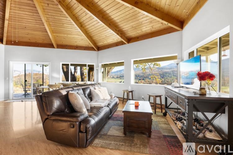 A living room with a brown leather couch and a wooden coffee table.