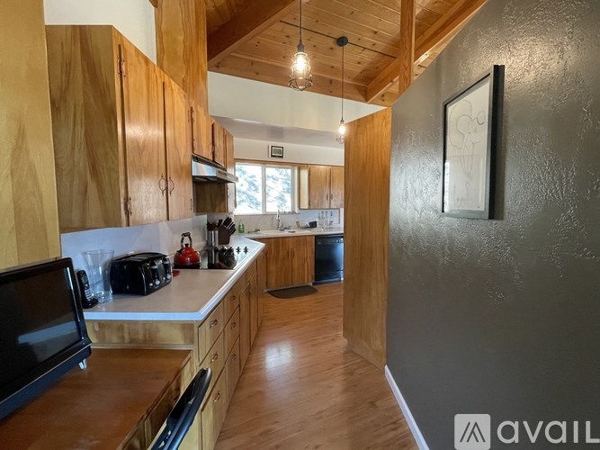 A kitchen with wooden cabinets and a black microwave.