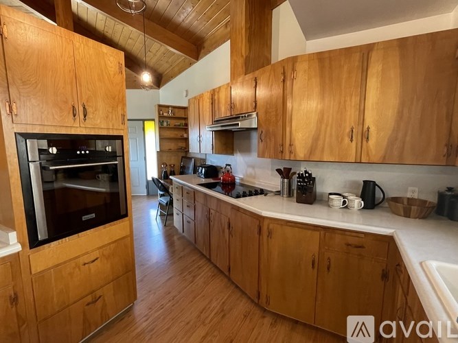 A kitchen with wooden cabinets and a black oven.