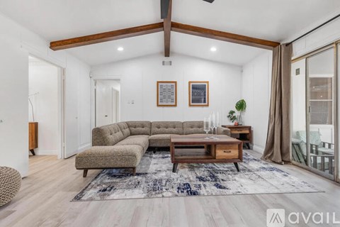 A living room with a grey sofa and a wooden coffee table.
